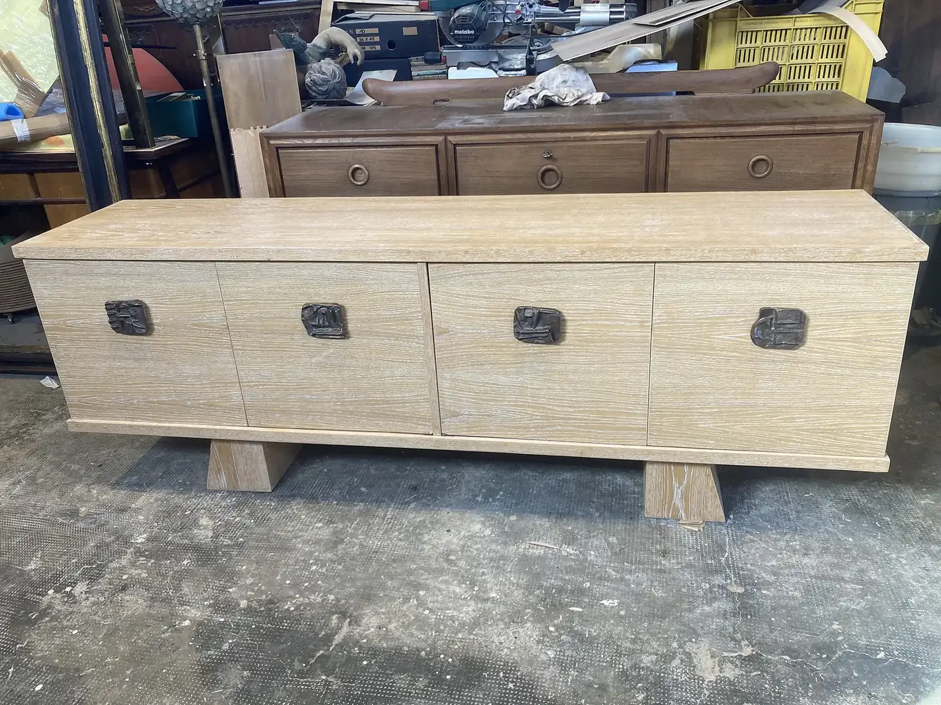 Credenza chiara con maniglie scolpite